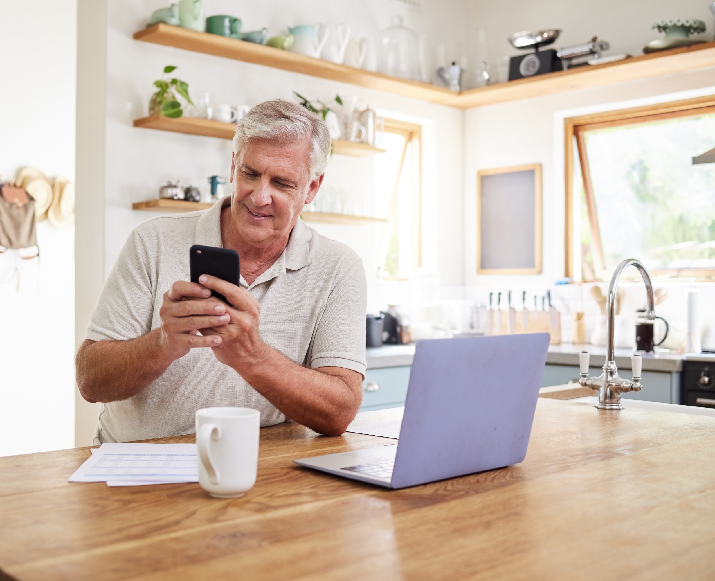 Older man texting on mobile device.